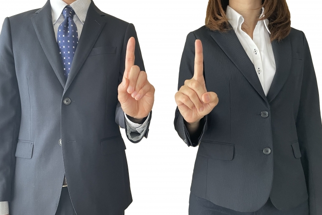 指を立て説明するビジネスの男性と女性